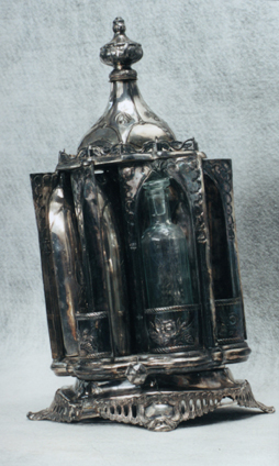 this is the silver plated mechanism viewed from the outside, with its base crushed, and its doors bent.  The mechanism was jammed and gears were cracked.